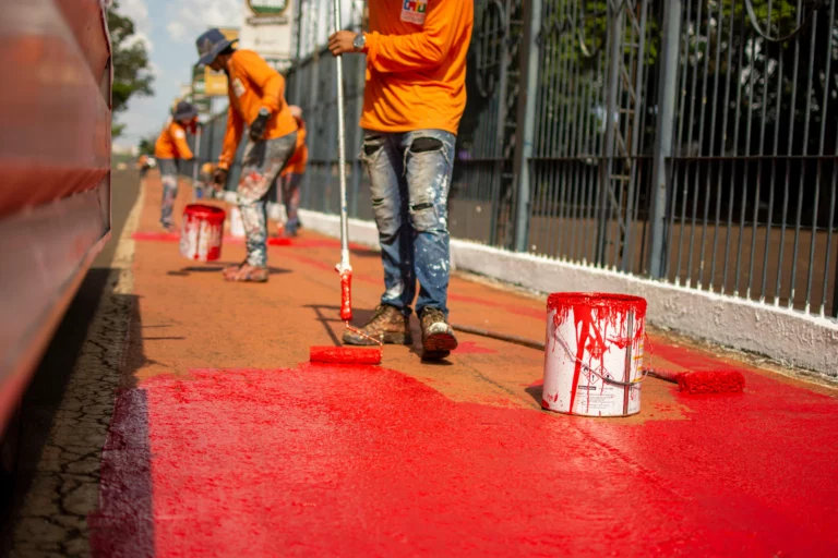 Hombre pintando el suelo de color rojo